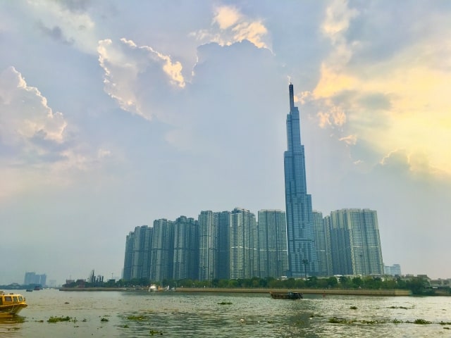 川沿いに高層マンション群と1本の超高層ビルが並ぶ東南アジアの都市の夕景。東南アジアは日系企業の進出が多く、語学力不問の求人も見つけやすい