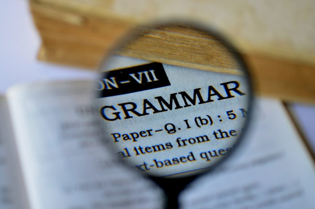 英文法の章の写真。虫眼鏡で英語の本の『GRAMMAR』という見出しを拡大している